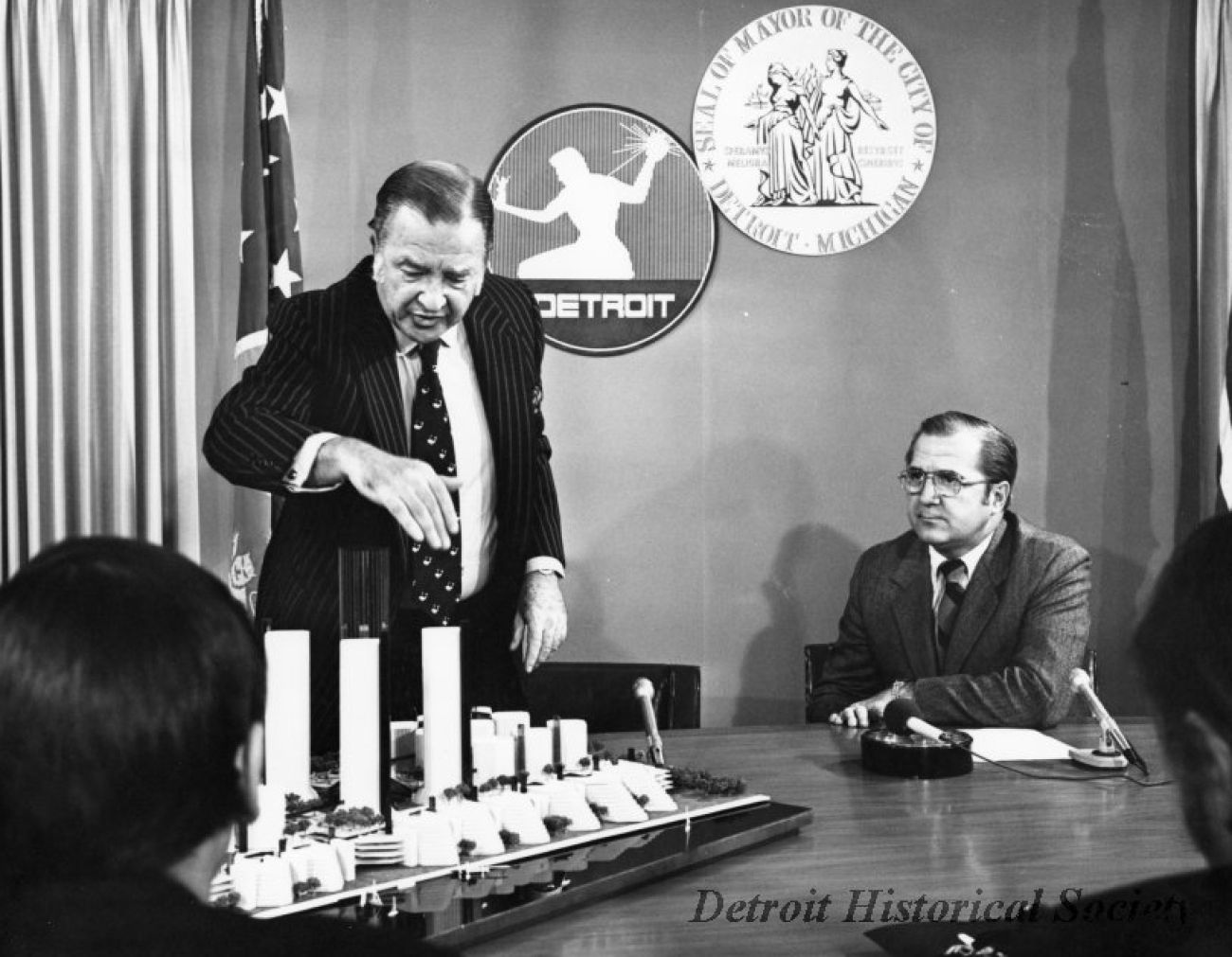 A black-and-white photo of Henry Ford II and Detroit Mayor Roman Gribbs at a press conference 