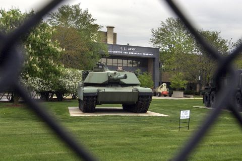 A huge tank can be seen through the gate.