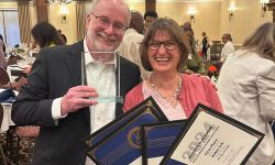 Ron French and Robin Erb smile and hold awards. 