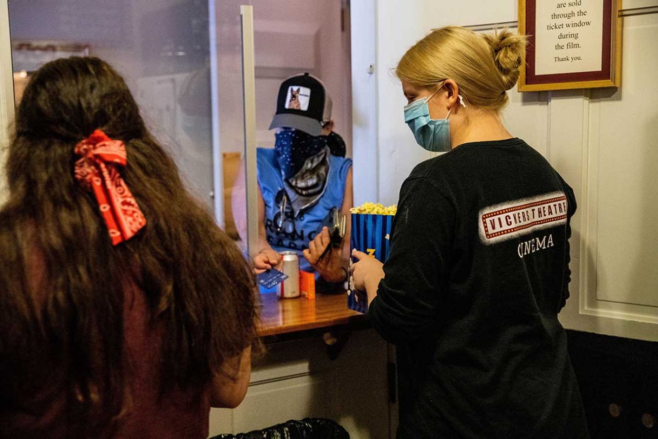 Concessions worker Olive Adnson passes a bag of popcorn to a customer at the Vickers Theatre in Three Oaks