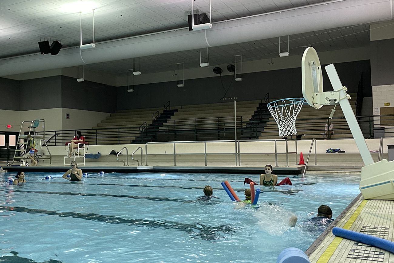 kids with noodles in a pool