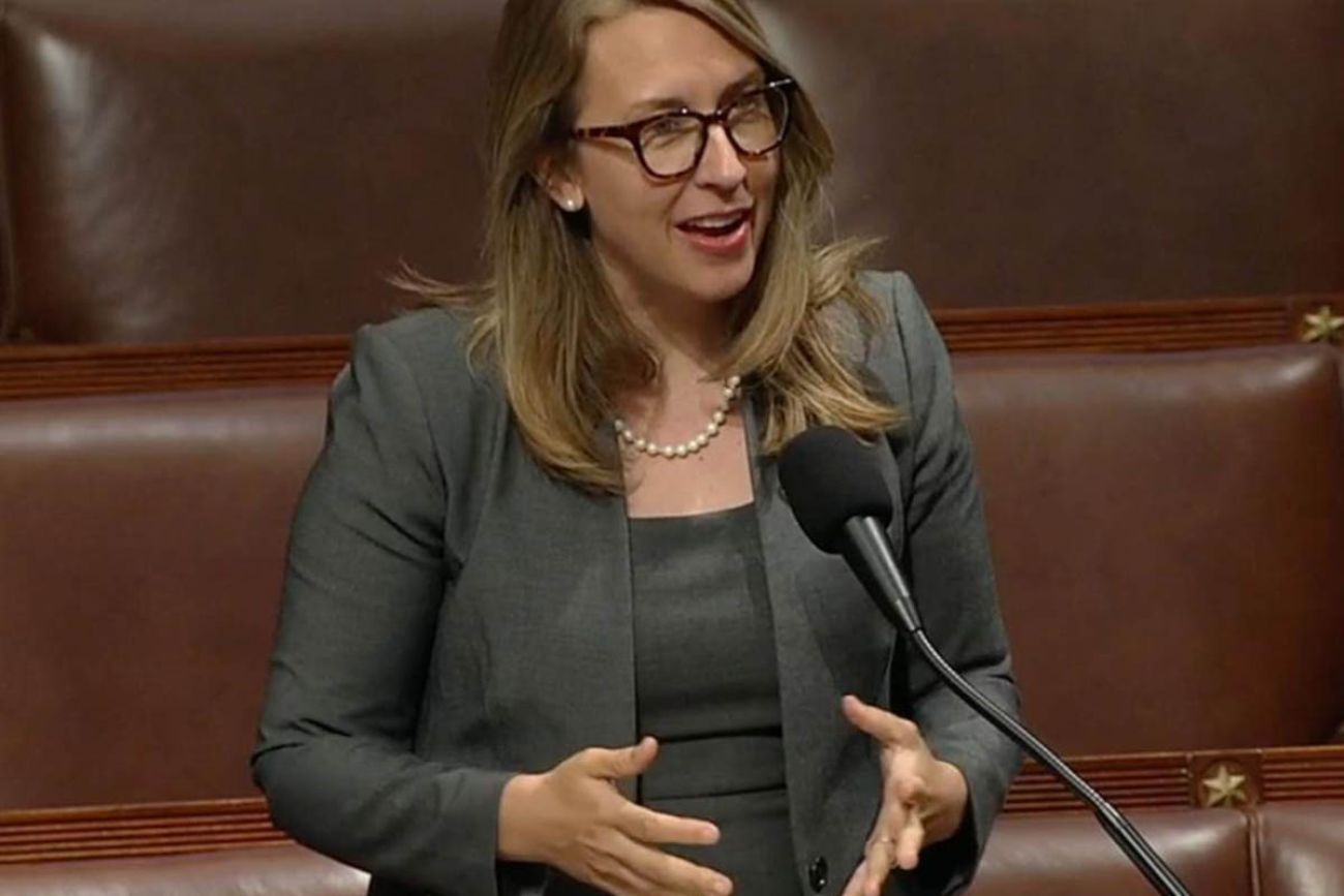 U.S. Rep. Hillary Scholten wearing a grey suit, speaking into a microphone