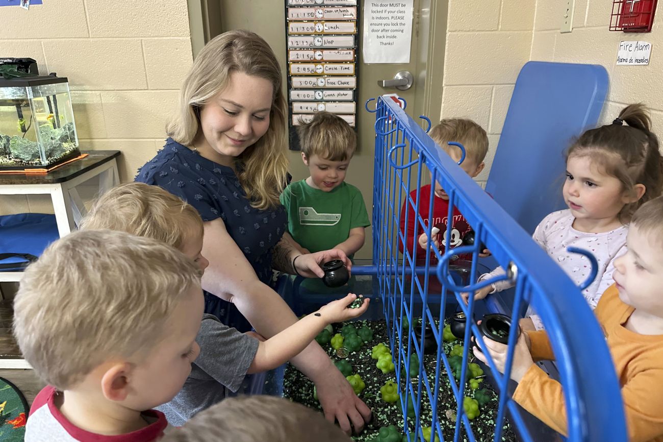 A teacher interacting with small children in a classroom