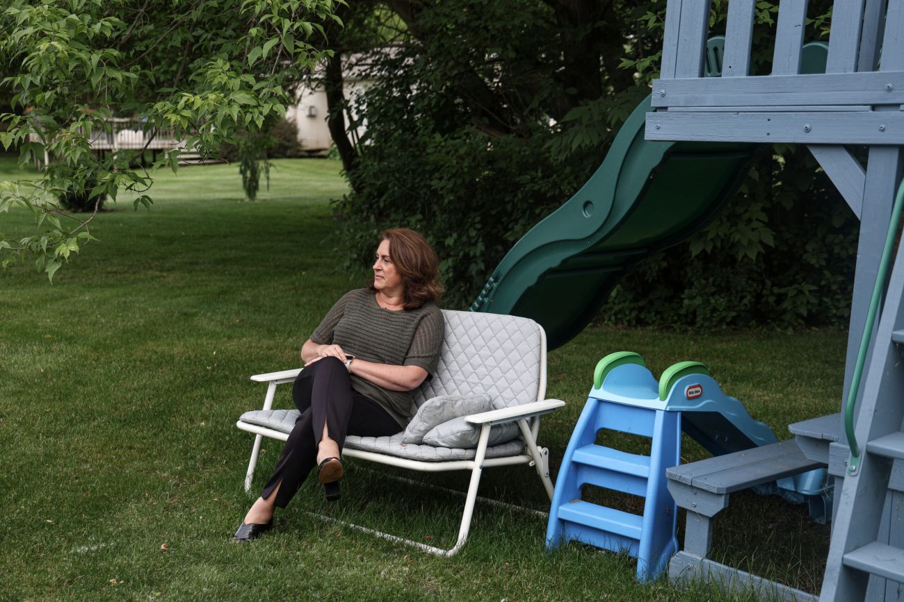 Tina Barton, the former city clerk of Rochester Hills sits on a grey chair outside