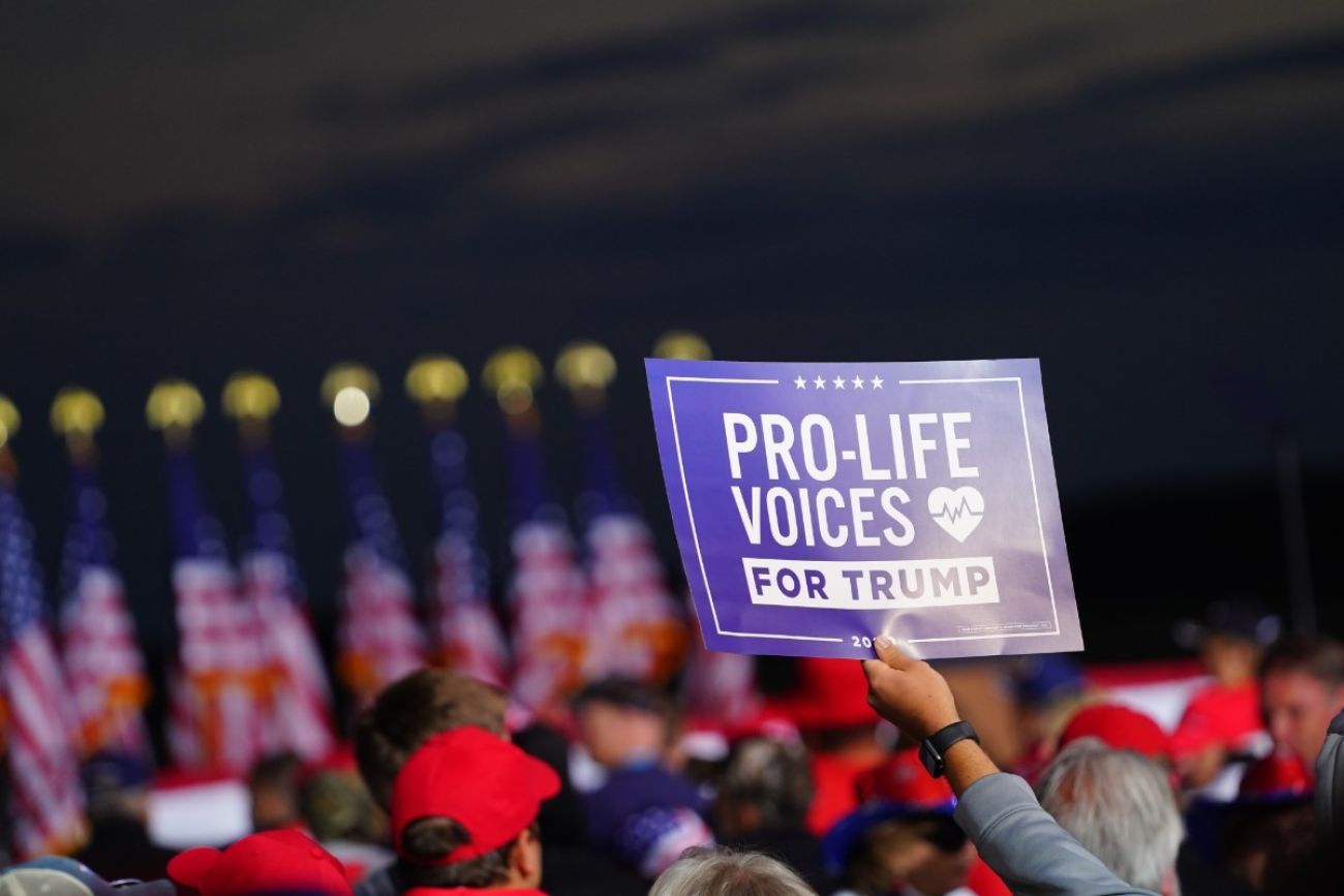 A person holding a sign that says "Pro-Life Voices for Trump"