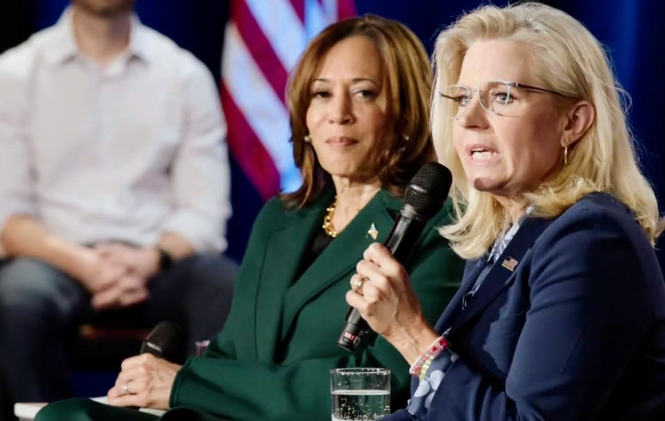 Liz Cheney, speaking into a microphone, sits next Kamala Harris