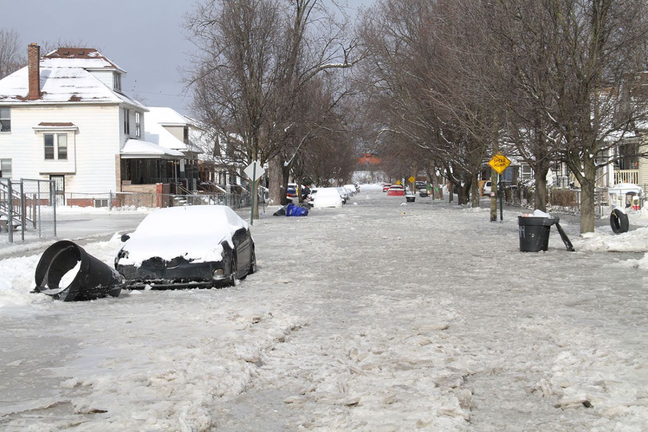 The Detroit road is covered in ice. You can see a car covered in snow. 