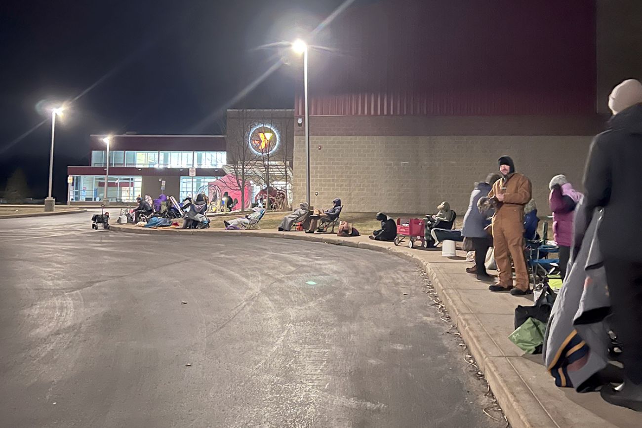 People waiting outside the Grand Traverse Bay YMCA. It's dark outside. 