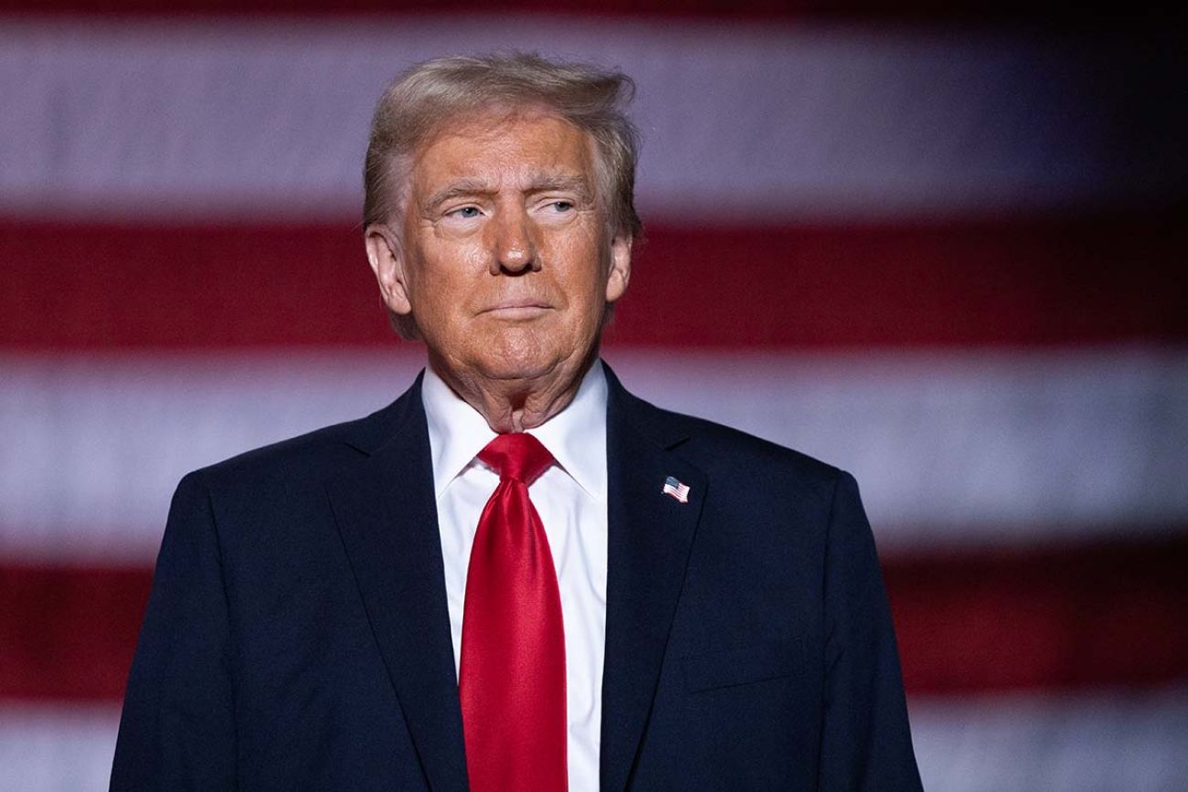 President Donald Trump wears navy suit and red tie. 