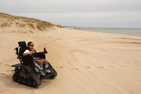 man in wheelchair on beach