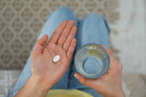 young woman holding a pill