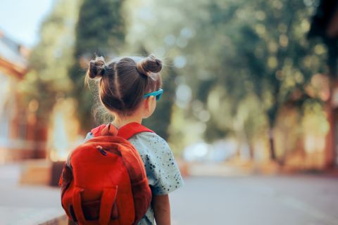  Child wearing a backpack ready for the first day of kindergarten