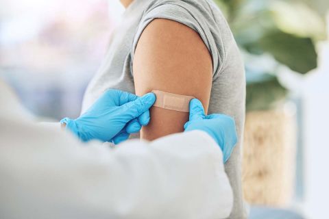 vaccine and doctor hands with plaster on patient arm in a medical hospital or clinic. 