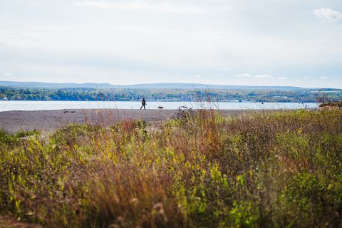 A woman walks her dog at Sand Point, a beach made of stamp sands on the Keweenaw Bay Indian Community reservation