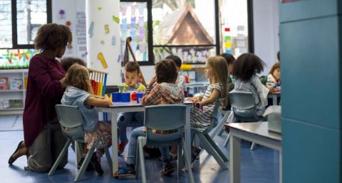 A teacher in a classroom with her students 