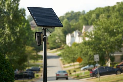 A solar-powered license plate reader mounted on a pole outside