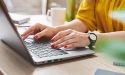 Cropped image of business woman hand working laptop computer in home office