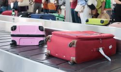 Suitcases on a baggage carousel at an airport during a busy travel day