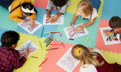 A group of kids drawing on the floor