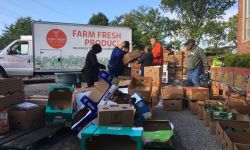 People filling up boxes to go into a van. 